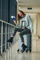 Can't wait for the flight. With tickets and luggage. Young woman in airport hall photo