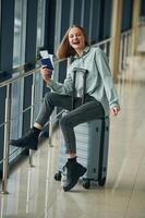 Can't wait for the ,flight. With tickets and luggage. Young woman in airport hall photo