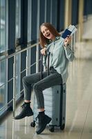 Can't,, wait for the flight. With tickets and luggage. Young woman in airport hall photo
