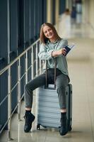 Can't, wait for the flight. With tickets and luggage. Young woman in airport hall photo