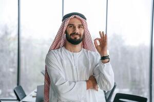 In,, traditional outfit.,., Successful Muslim businessman is in his office photo