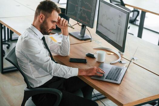 Using laptop,,. Businessman is sitting by computer and working in the office photo