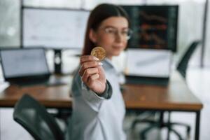 Digital currency, conception ,of stock. Golden coin in hand. Businesswoman is working in the office photo
