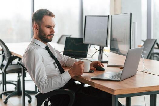 Using laptop.. Businessman is sitting by computer and working in the office photo