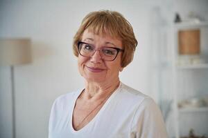 Portrait of senior elderly woman, that, is at home in the living room photo