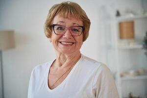 Portrait of senior, elderly woman that is at home in the living room photo
