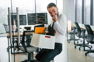 Showing middle finger. Unemployed man is with personal belongings, after, being ,fired photo