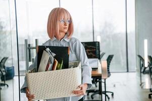 With personal belongings ,in ,the box. Unemployed woman is after being fired photo