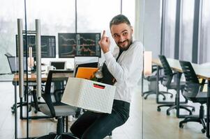 Showing middle finger. Unemployed man is with personal belongings after being, fired photo