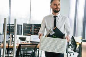 Sad person. Unemployed man is with personal belongings after being fired photo