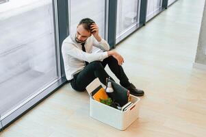 By ,the, panoramic windows, sitting. Unemployed man is with personal belongings after being fired photo