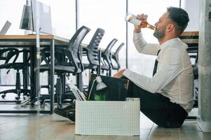 Drinking alcohol., Unemployed man is with personal belongings after being fired photo