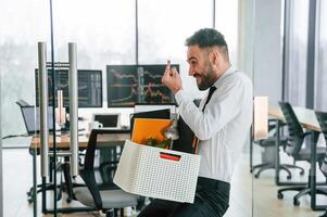 Showing, middle finger. Unemployed ,,man is with personal belongings after being fired photo