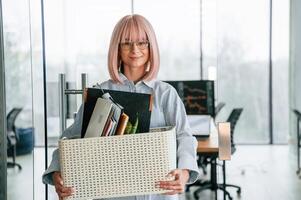 With ,personal, belongings in the box. Unemployed woman is after being fired photo