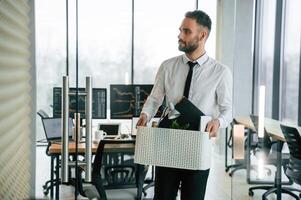 Sad person. .Unemployed man is with personal belongings after being fired photo