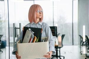 With personal belongings in the box... Unemployed woman is after being fired photo