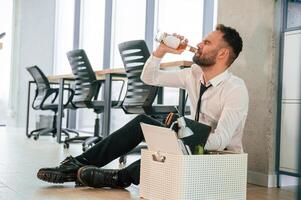 Drinking alcohol.. Unemployed man is with personal belongings after being fired photo