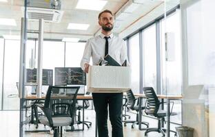 Front, view. Unemployed man is with personal belongings after being fired photo