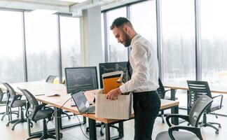 With box in ,hands. Unemployed man is with personal belongings after being fired photo