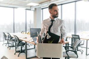 With box in, hands. Unemployed man is with personal belongings after being fired photo
