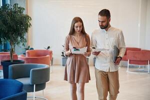 Walking, forward, holding ,documents. Man and woman are on the way to work to office photo