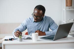 Doing some paperwork.. Businessman, is in the office by laptop photo