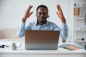 Failure, with hands up, shocked. Businessman is working in the office by laptop photo