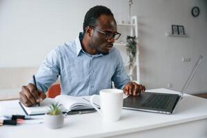 Doing some paperwork.,, Businessman, is in the office by laptop photo
