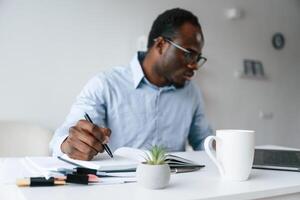 Doing some, paperwork. Businessman is in the office by laptop photo