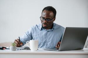 Manager is, using, laptop. Businessman is working in the office photo