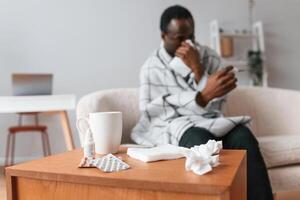 Looking, at, thermometer,. Sick black man is at home photo