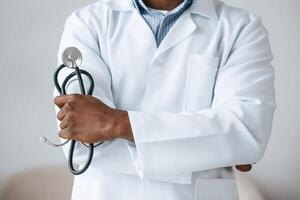 Standing, and ,holding stethoscope. Black man as doctor in the clinic office photo