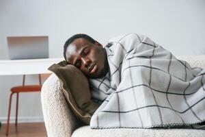 Lying ,down ,on the sofa. Sick black man is at home photo