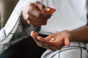 Taking the, pills. Sick black man is at home photo