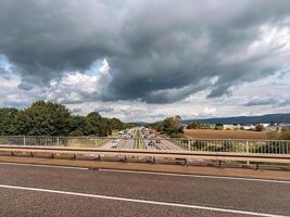 Highway with a bridge over it and a cloudy sky photo