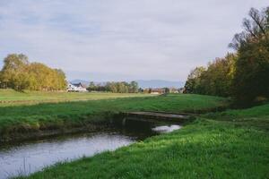Grassy field with a small stream running through it photo