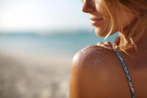 Sunscreen lotion drop on shoulder at beach photo