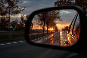 Sunset road view in car rear view mirror reflection photo