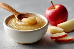 Smooth applesauce in bowl with fresh apples photo