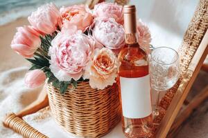 A bottle of wine and a basket of flowers on the beach photo