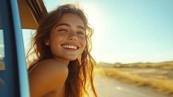 Woman with long hair is smiling and looking out the window of a car photo