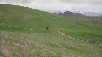Slow Motion of Green Pastures on Hills with Mountains and Dark Clouds video