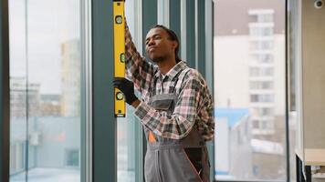Focused construction worker leveling window frame video