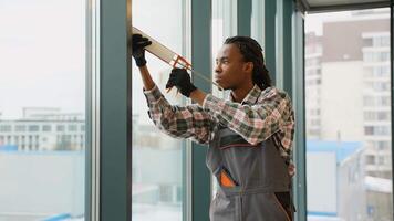 Focused worker sealing window frame in office video