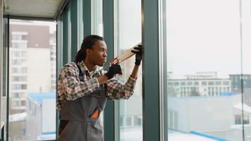 Worker applying sealant to large glass window video