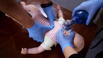 Demonstrating chest compressions on CPR doll. CPR training medical procedure on a dummy child. First aid. Top view. video