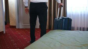 Man with suitcase leaving the room. Businessman in black trousers taking his luggage and moving to the door in the hotel. The end of business journey. video