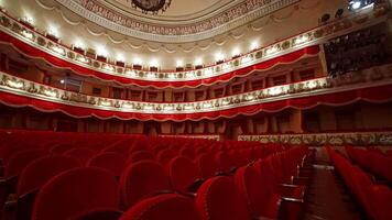 Theatrical hall with no people. Large auditorium with comfortable red chairs of a classical theater. Empty theater during lockdown. video
