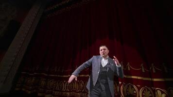 Comedian rehearsing on scene. Happy male actor performing in the theater dancing and singing on stage. Orbital shot. video