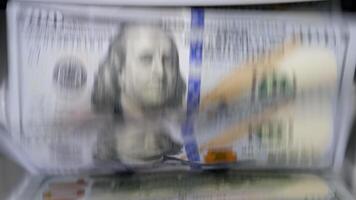 Currency counting machine. Automatic equipment for banking financial transactions. Counter machine with US money banknotes of 100 dollars. Bank automatic equipment for counting cash money. Macro shot. video